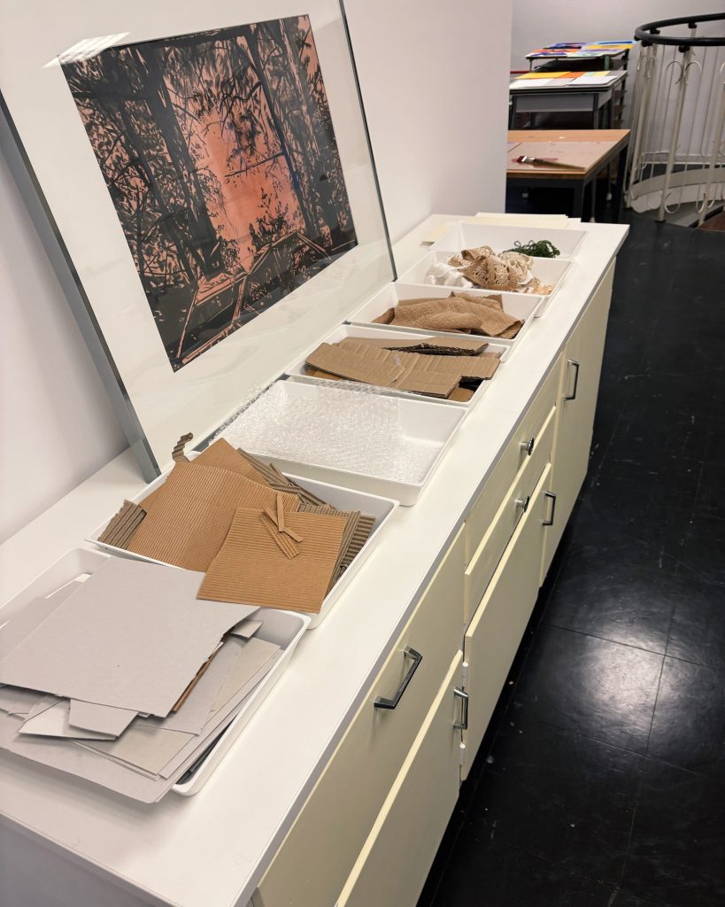 Schrank mit verschiedenen Materialien wie Pappen, Kartons und Papier darauf.